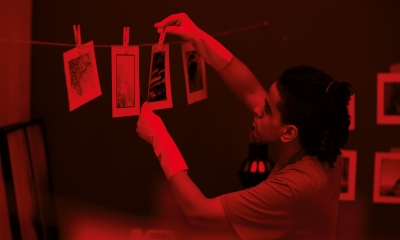 Young,Photographer,Hanging,Colored,Printed,Photos,In,Darkroom,With,Red