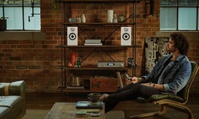 607 S2 Anniversary Edition – Matte White – Male Listening in Chair with Phone Front 1 – looking at speakers