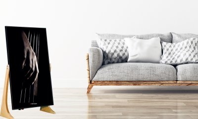 Divano industrial grigio con cuscini in stanza con parquet rende