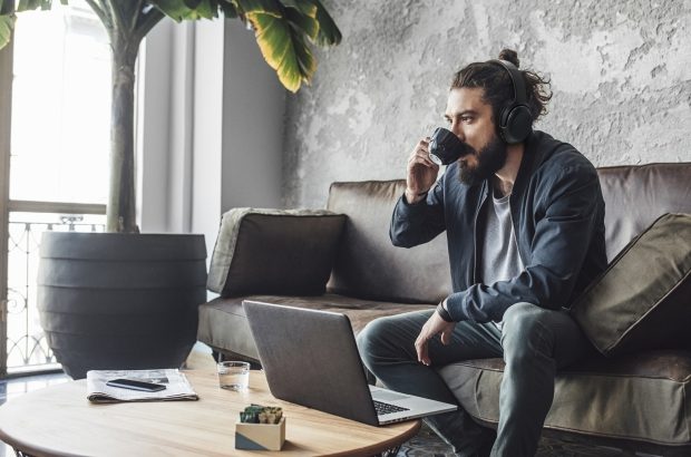 Handsome modern Caucasian man with beard drinking coffee.